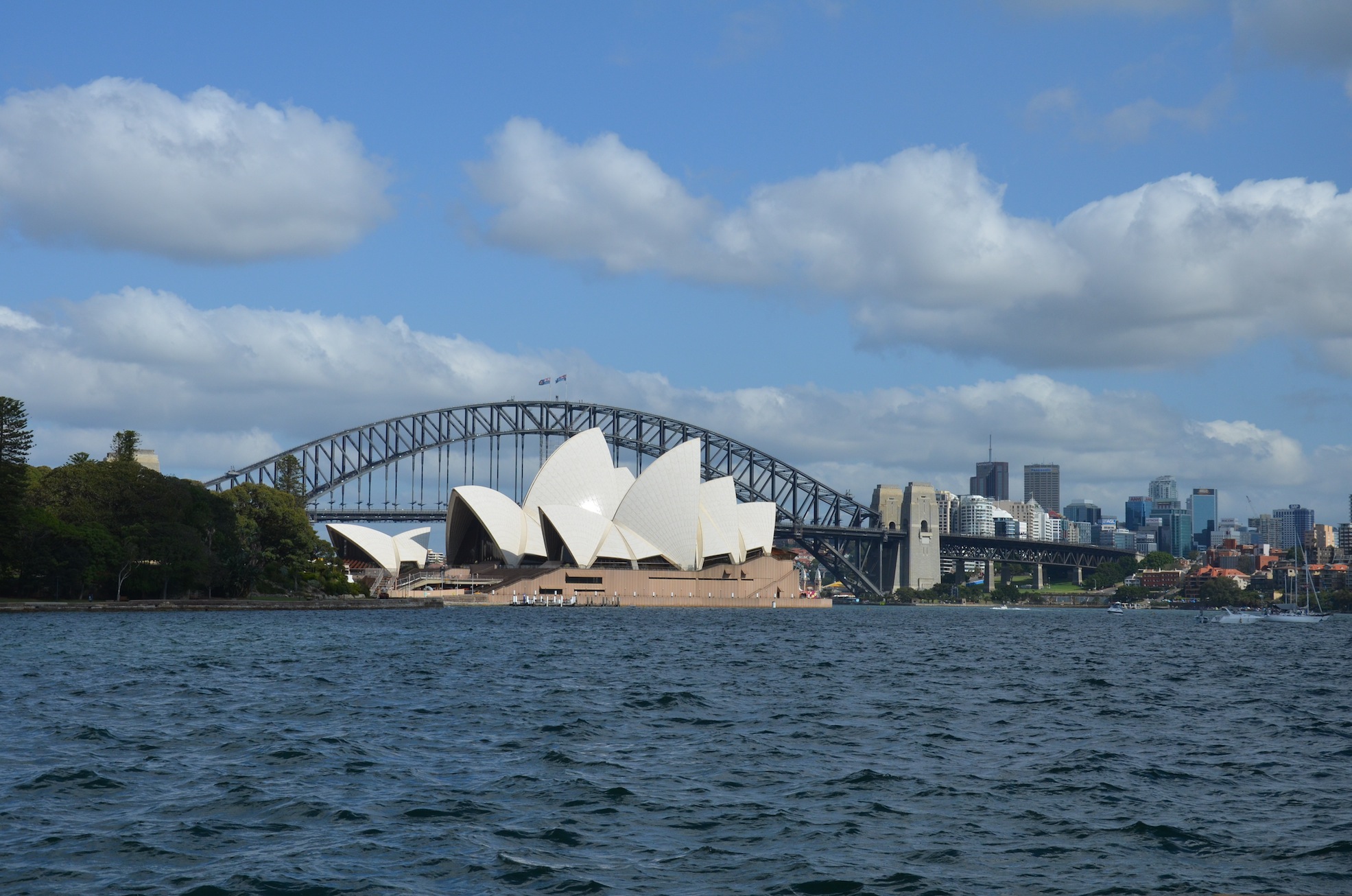 sidney's opera surrounded with the sea and the skyline of the city